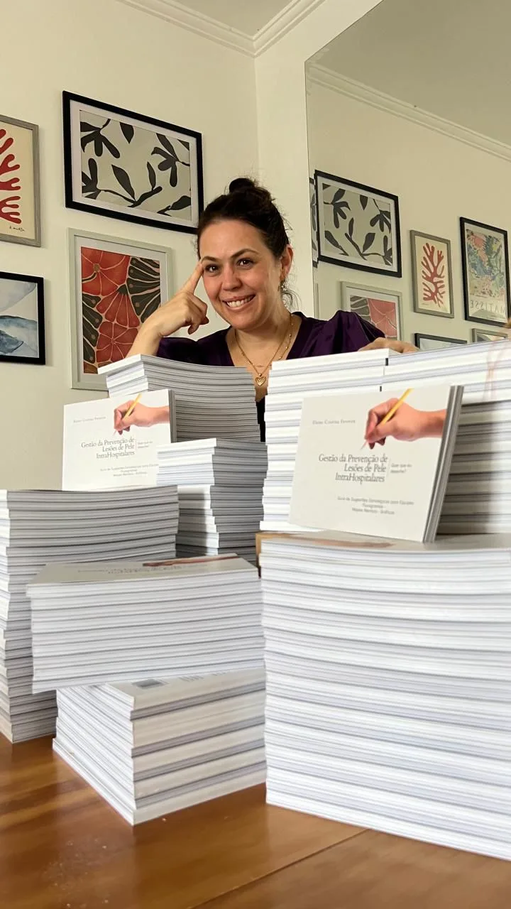 Elaine Ianni, enfermeira estomaterapeuta, com pilhas do Guia da Gestão da Prevenção de Lesões de Pele